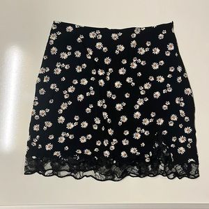 Stradivarius black daisy print skirt with lace hem and small side cutout in XS.